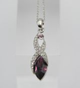 A white metal Swarovski pendant on a white metal chain, with white and purple stones, boxed.