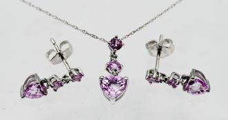 A 10ct white gold and pink sapphire set, to include a pair of earrings, and pendant on a chain. (3)