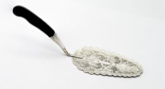A white metal cake slice, with engraved foliate design.