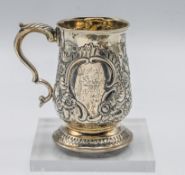 A late 18th century silver mug, with embossed foliate decoration, engraved with lion, hallmarked