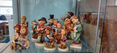 A collection of Hummel figurines, including 'Stormy Weather 71' and 'Heavenly Angel', marked