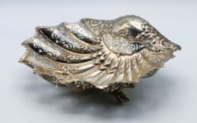 A silver bowl, of shell shape and pierced and embossed foliate decoration, on three conch shell