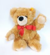 A Steiff teddy bear with red bow tie with Steiff paper bag.