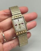 A 14ct lady's Swiss Chalet Watch on a gilt expanding chain, dial set with red and white stones.