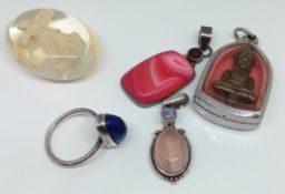 Three silver pendants with stones, one with a buddha figure, together with a white metal ring, and