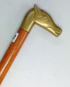 A tan brown walking stick, with brass horsehead handle, length 87cm. Sold on behalf of the