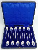A set of twelve silver teaspoons, twisted handles with robed figure decoration, boxed, hallmarked