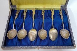 A set of six Japanese silver teaspoons, cased, with engraved foliate design and stylised handles,