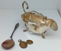 An early 20th century silver gravy board and spoon, silver weight 3.17, together with a gilt locket.