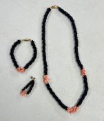 A jet and coral necklace with matching bracelet and one matching earring.