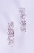 A pair of 18ct white gold half hoop style earrings set with round brilliant cut diamonds, total