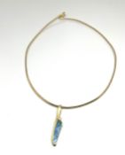 A natural boulder opal multi coloured pendant set with a diamond, on a yellow gilt chain, with a