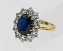 A fine 18ct sapphire and diamond cluster ring, set in yellow gold, with an oval brilliant cut