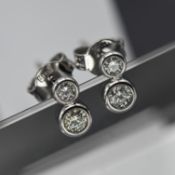 A pair of 18ct white gold diamond stud earrings each earring set with two stones.