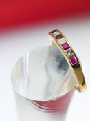 An 18ct yellow gold ruby and diamond eternity ring, size V.