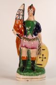 Staffordshire military themed figure bearing an orange flag with sword and shield in hand, re-