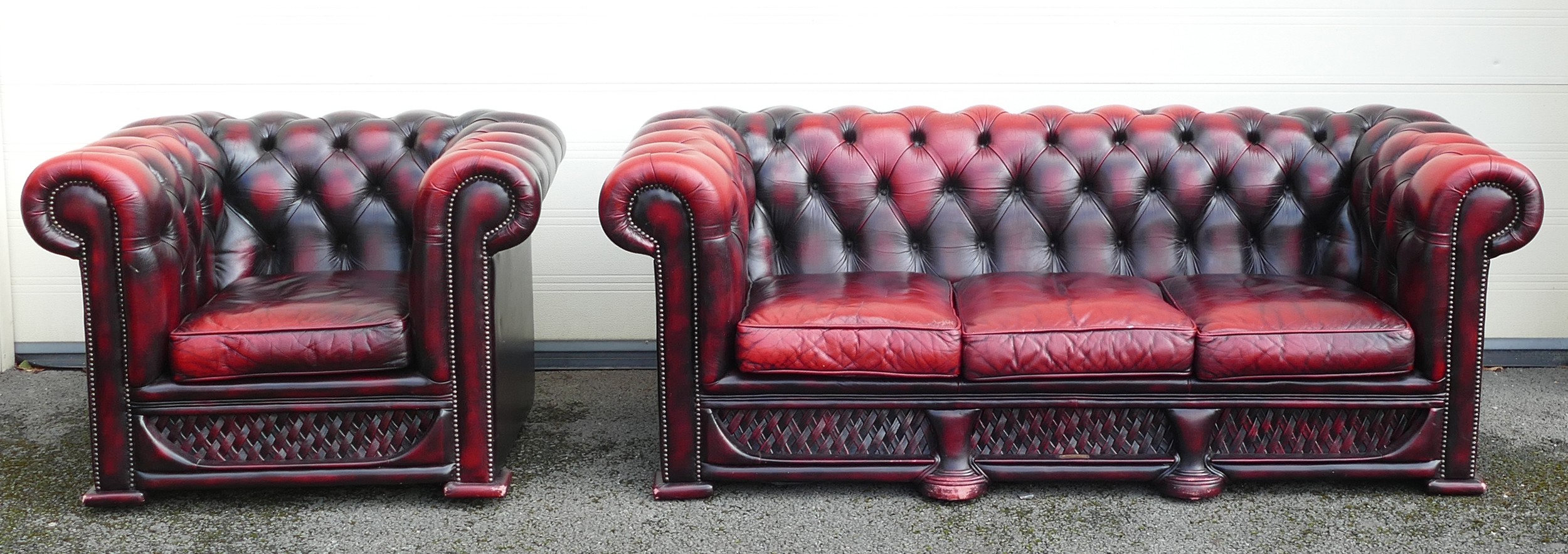 Leather by Design, Ox-Blood red Chesterfield settee and armchair. Small brass plaque to centre of