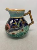 Majolica Handled Fish Jug with a polychrome underwater scene around the body. small chip to rim.