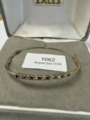 9ct yellow gold bangle set with alternating sapphire and diamonds, AF, clasp not working, marked 9ct