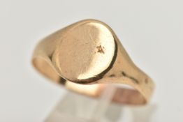 A YELLOW METAL SIGNET RING, of an oval polished form, misshapen shank, approximate gross weight 3.