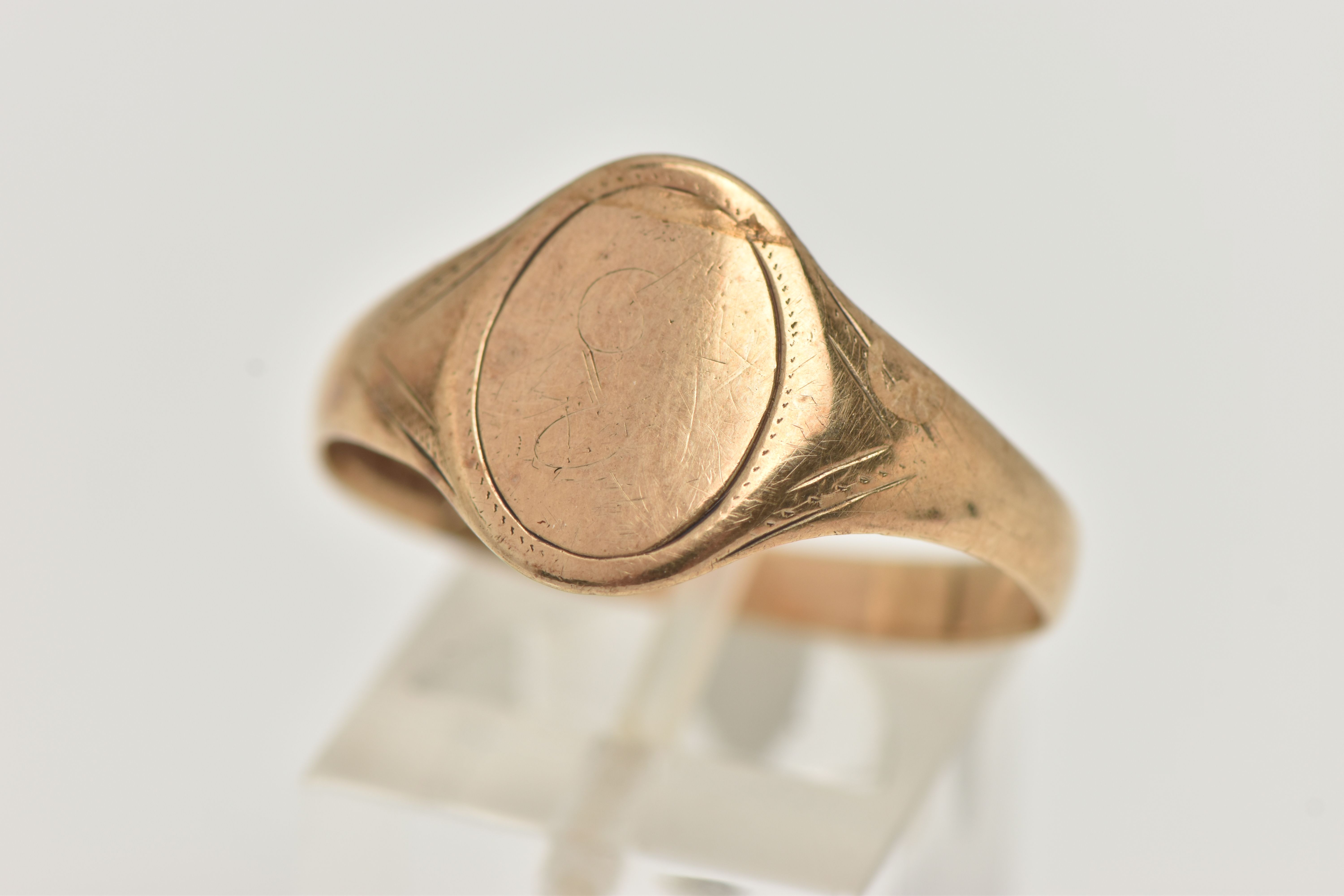 A 9CT YELLOW GOLD SIGNET RING, of an oval form, worn engraving, misshapen shank, hallmarked 9ct