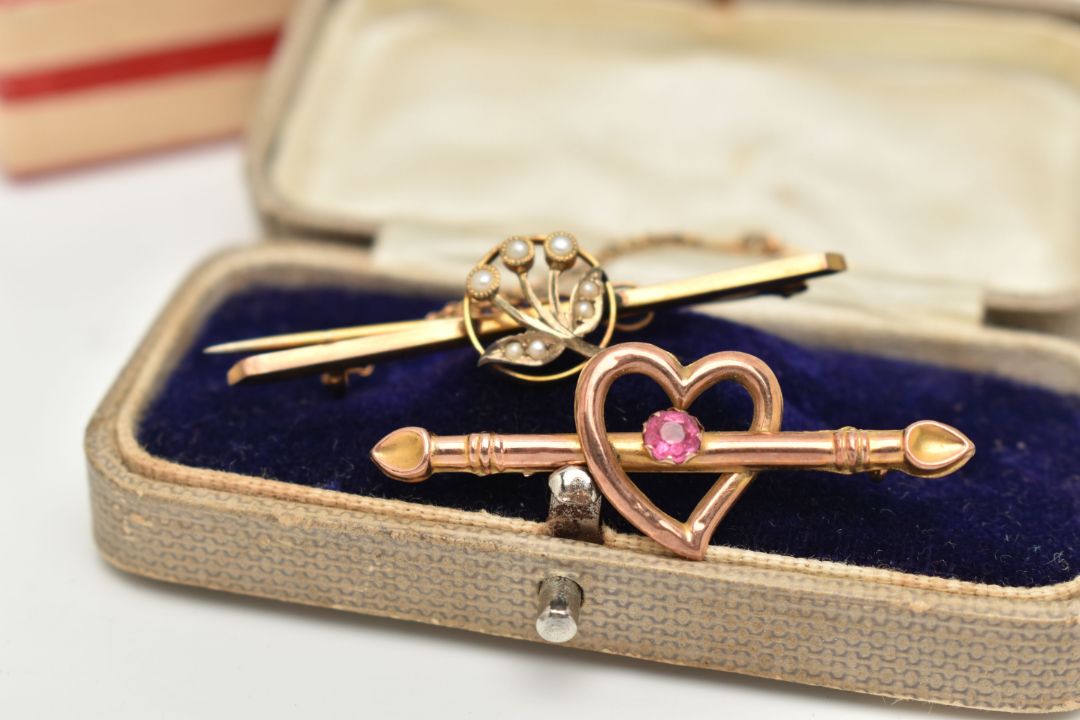 TWO EARLY 20TH CENTURY BROOCHES, the first an open work heart with bar set with a single pink - Image 1 of 4