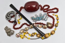 A SMALL BAG OF ITEMS, to include a large oval cherry amber colour Bakelite bead fitted on a red