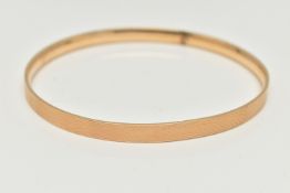 A 9CT GOLD METAL CORE BANGLE, engine turned pattern, stamped '9ct gold solid metal core',