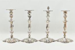 A GEORGE V SILVER SET OF FOUR CANDLESTICKS IN GEORGE II STYLE, with removable shaped square drip