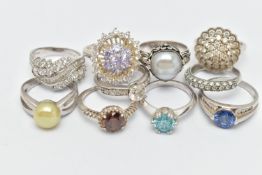 TEN WHITE METAL RINGS, to include various designs set with cubic zironia, including cluster rings,