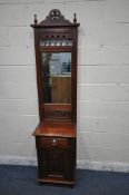 A REPRODUCTION MAHOGANY HALL STAND, the twin finials flanking a shaped crest, turned supports, a