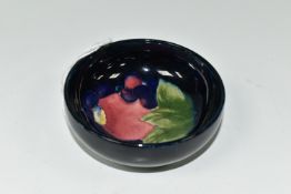 A MOORCROFT POTTERY 'POMEGRANATE' SMALL FOOTED BOWL, tube lined in the Pomegranate pattern on a dark