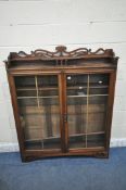 AN EARLY 20TH CENTURY OAK BOOKCASE, with raised back, double glazed doors, enclosing three