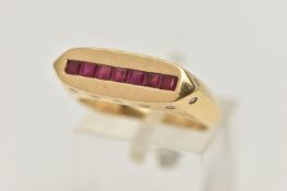 A YELLOW METAL GEM SET SIGNET RING, a rectangular form signet ring, channel set with seven square