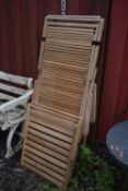 A PAIR OF TEAK FOLDING SUN LOUNGERS, with loose footrests (condition report: some weathering, but