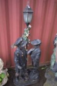A FIGURAL GARDEN LANTERN, that's behind a boy and girl, height 178cm (condition report: finish