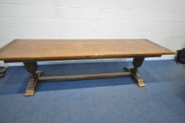 A 20TH CENTURY OAK TABLE, the two inch rectangular top, raised on bulbous carved supports, shaped