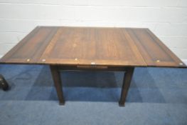 AN ARTS AND CRAFTS OAK DRAWER LEAF DINING TABLE, raised on square tapered legs, with pad feet,