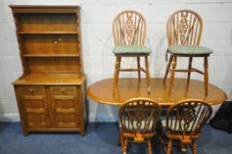 A LATE 20TH CENTURY OAK OVAL EXTENDING DINING TABLE, with one additional fold out leaf, open