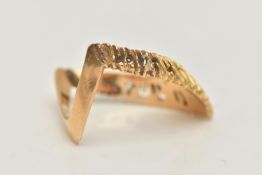 A YELLOW METAL TEXTURED WISH BONE RING, textured V shape, and polished reverse, stamped 750, ring