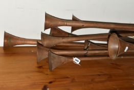A COLLECTION OF THIRTEEN ASSORTED COPPER HUNTING HORNS, together with a copper washing 'Dolly'