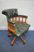 A REPRODUCTION SWIVEL OFFICE CHAIR, with buttoned green leather upholstery, raised on five shaped