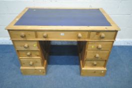 A LATE 20TH CENTURY PINE TWIN PEDESTAL DESK, with a blue leather writing surface, fitted with nine