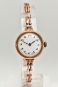 A 1920'S 9CT GOLD WRISTWATCH, the circular white face with black Arabic numerals, expandable stretch