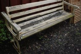 A PAINTED CAST IRON AND TEAK RAILWAY BENCH, with a central pivot that allows backrest to move sides,