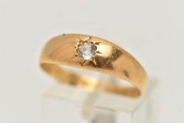 A YELLOW METAL SINGLE STONE RING, star set with a colourless circular cut sapphire, to a polished