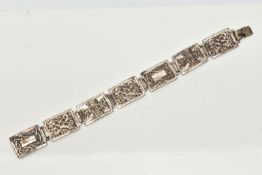 A SILVER CELTIC ARTICULATED BRACELET, designed as a series of seven rectangular panels each with a