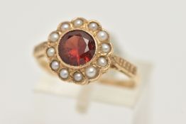 A YELLOW METAL GARNET AND SPLIT PEARL CLUSTER RING, of a circular form set with a central circular