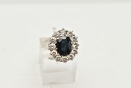 A 9CT WHITE GOLD CLUSTER RING, of an oval design, set to the centre with a deep blue oval cut