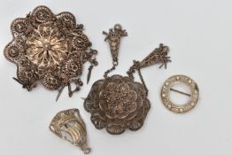 FOUR ITEMS OF JEWELLERY, to include a white metal filigree flower brooch with two tassels, fitted